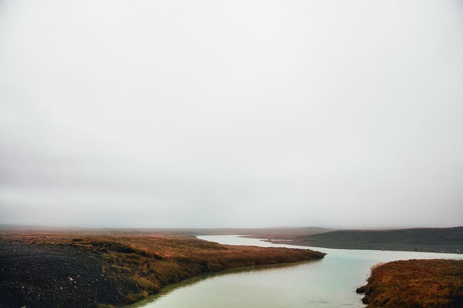 Panoramic view of gray cloudy sky over the fall field and a river stream HD wallpaper