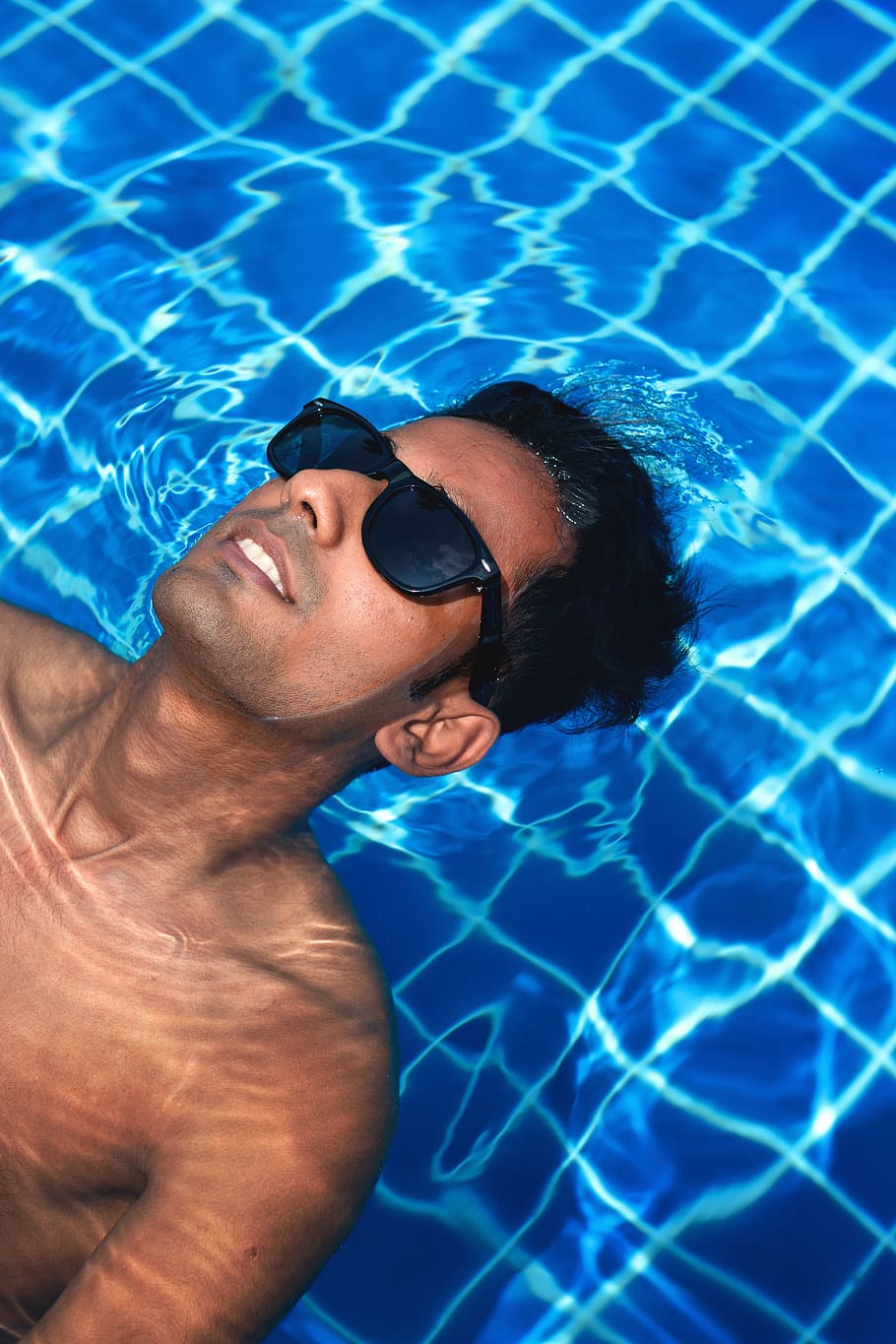man wearing black framed sunglasses floating on body of water HD wallpaper