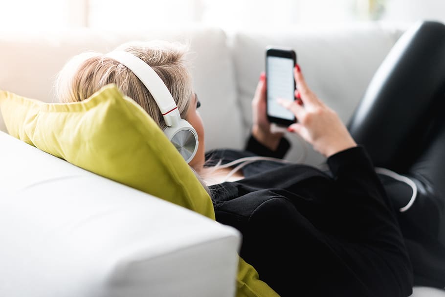 Woman Listening to Music on a Sofa, bedroom, headphones, home