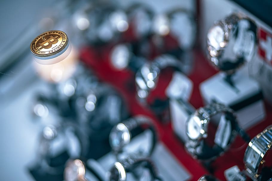 Shining Gold-plated Physical Bitcoin on Glass Shelf Inside a Luxury Watches Shop HD wallpaper