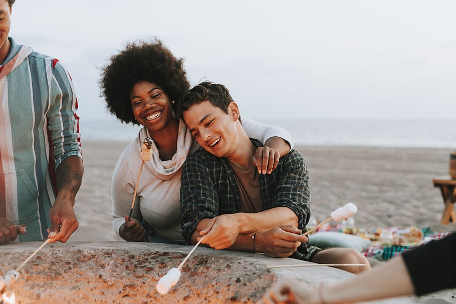 Man and Woman Holding Stick, activity, bbq, cheerful, coast, facial expression HD wallpaper
