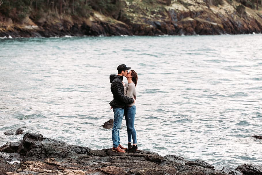 couple kissing on rock beside sea during daytime, human, person, HD wallpaper