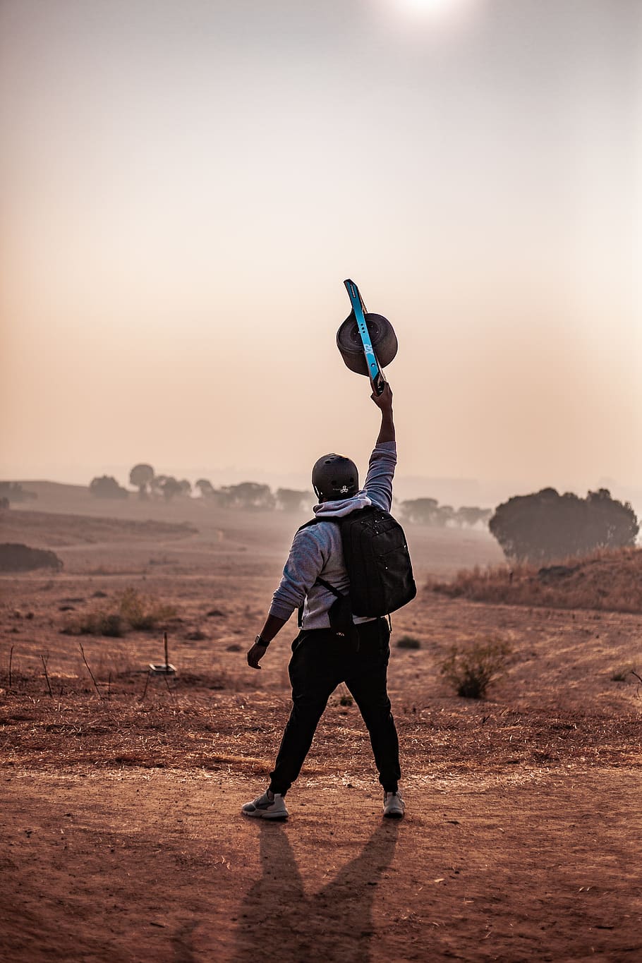 Man Holding Balance Board, backpack, dusk, environment, evening sun HD wallpaper