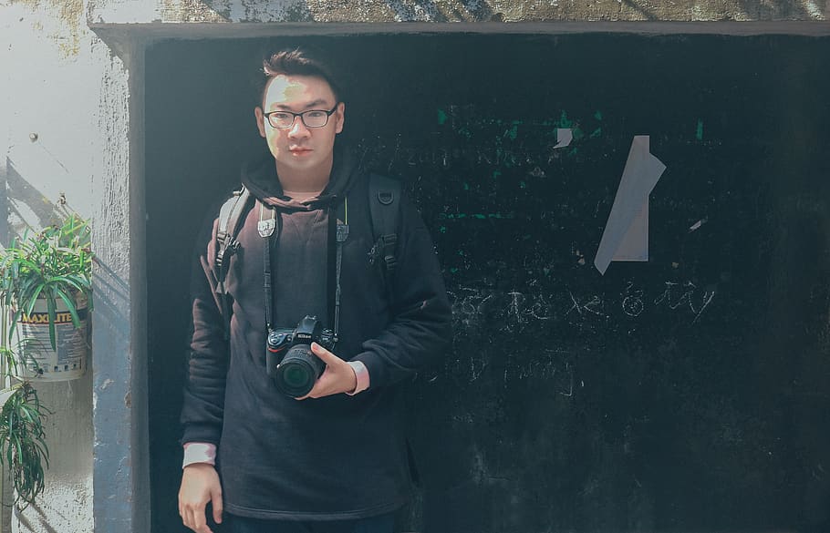 Man in Black Pullover Hoodie Holding Black Dslr Camera, daytime HD wallpaper