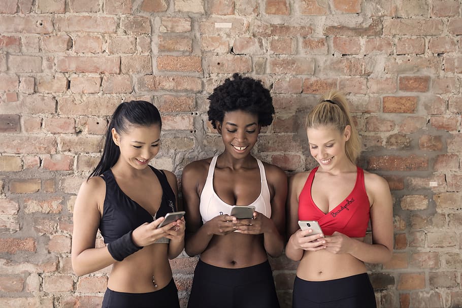 HD wallpaper: Three Woman in Assorted-color Sport Bras Holding and Watching  Their Smartphones