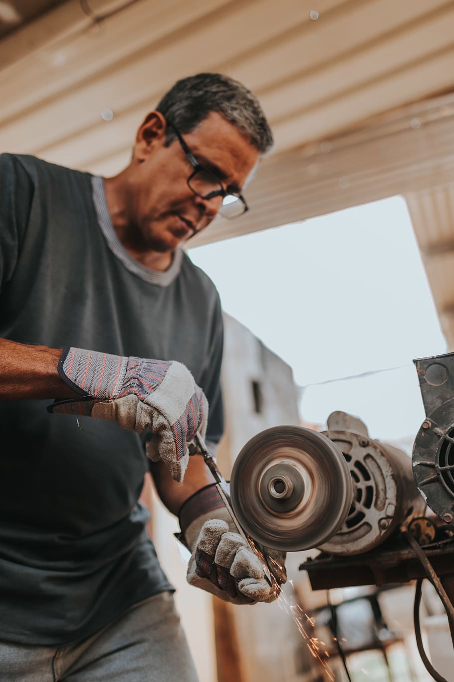 man standing beside bench grinder, human, person, machine, glasses HD wallpaper