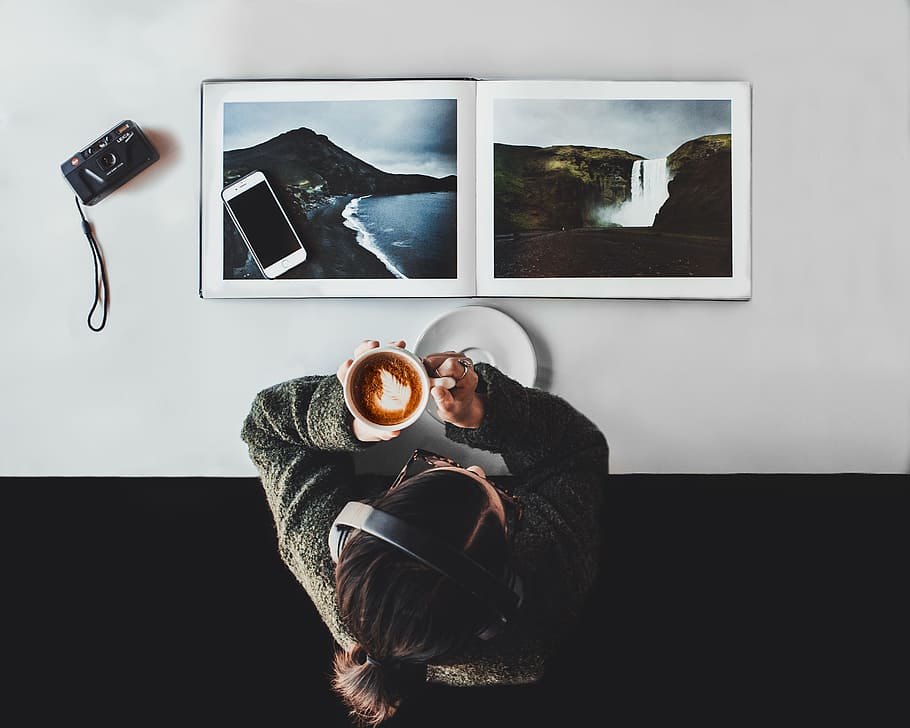 person drinking coffee white listening to headphones, table, book HD wallpaper
