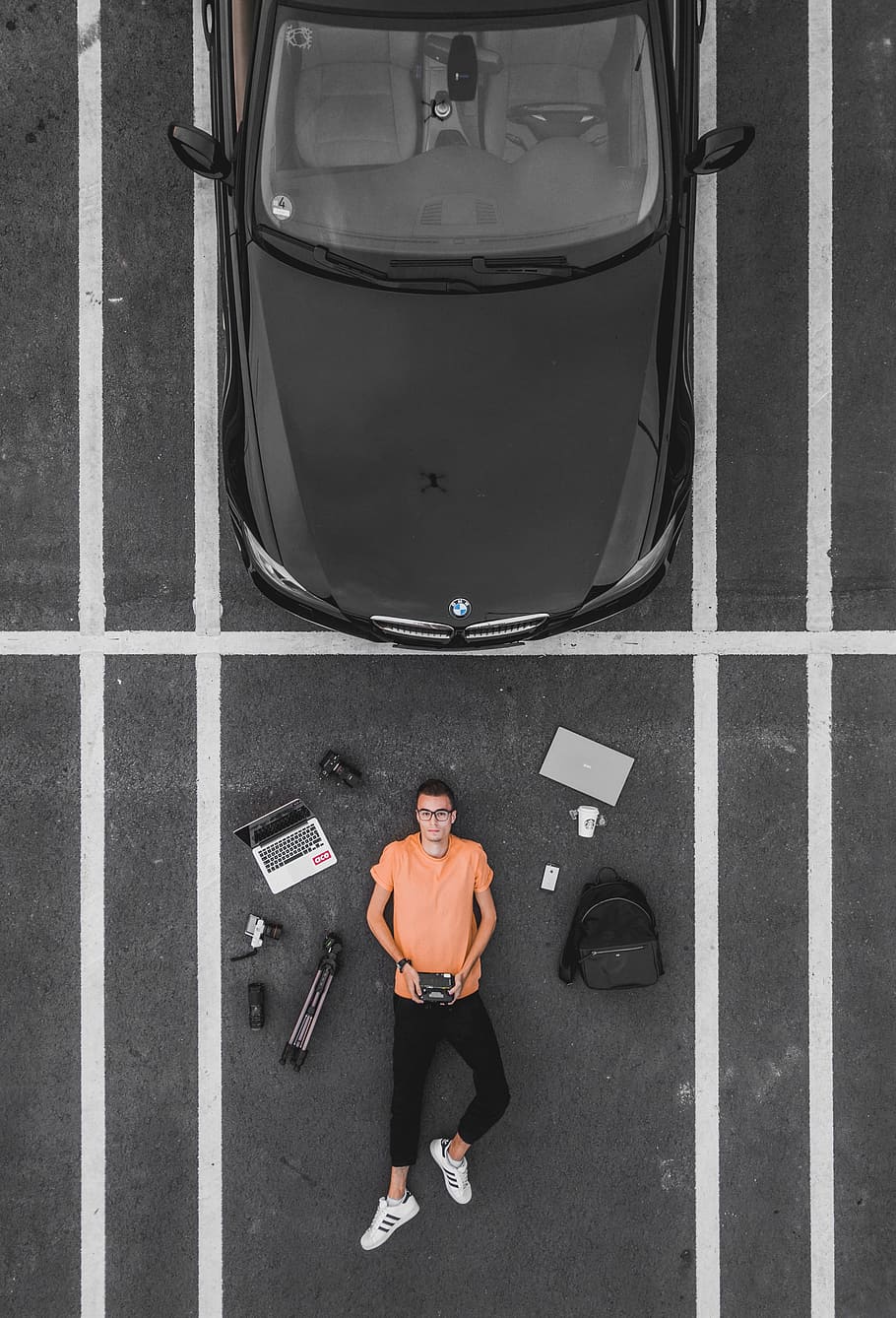 man lying on parking lot near black car, tech, flat, flatlay HD wallpaper
