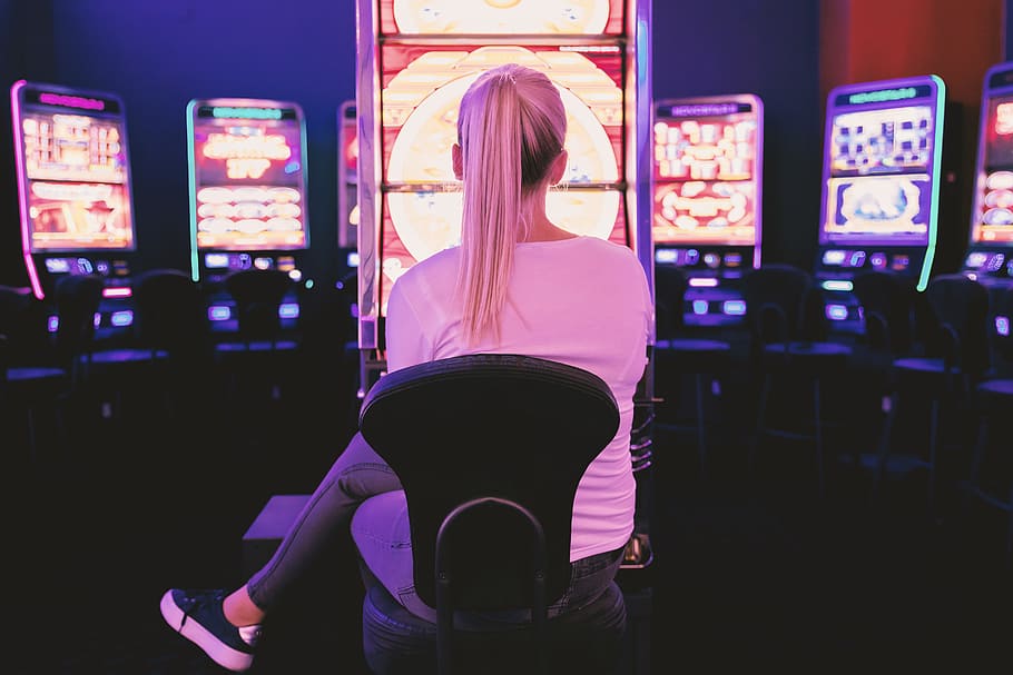 woman sitting facing arcade machine, female, fun, casino, gambling