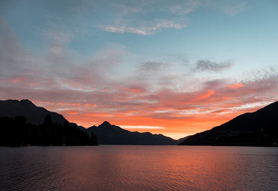 Body of Water Near Silhouette of Mountain Under White Clouds during Sunset HD wallpaper