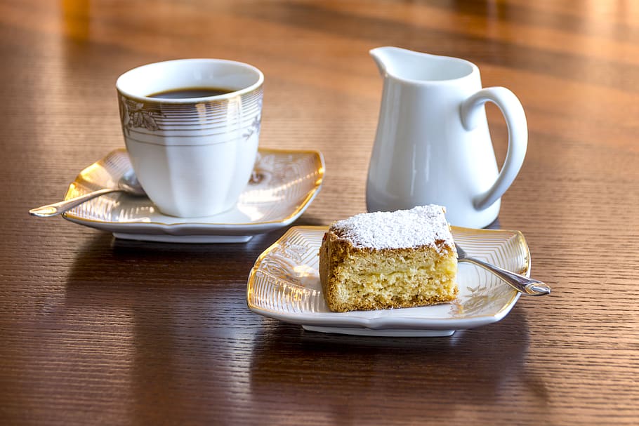 White Ceramic Mug Filled With Black Liquid Beside Baked Bread on Ceramic Saucer