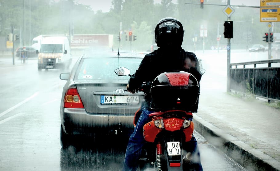 man riding red motor scooter with gray Toyota sedan in front of him during rainy daytime, HD wallpaper