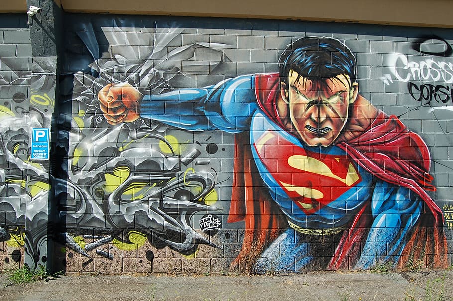 An intense graffiti painting of Superman on a building wall.