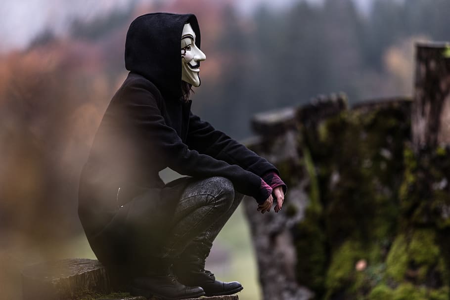 Photo of Person in Black Hoodie and White Mask, blur, close-up