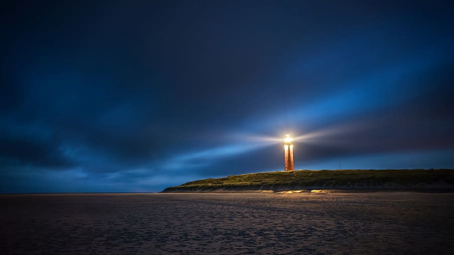 lighthouse under cloudy sky during nighttime, beach, illuminated HD wallpaper