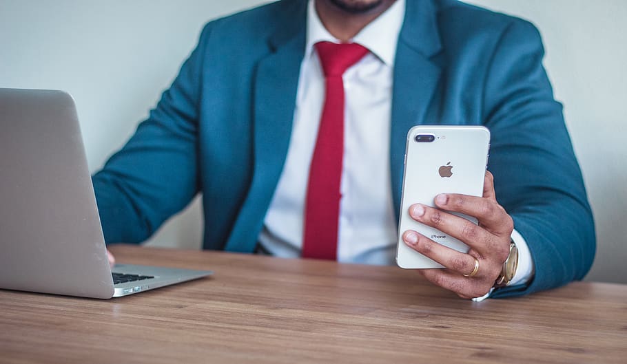 man sitting beside table holding silver iPhone 7 Plus, wireless technology HD wallpaper