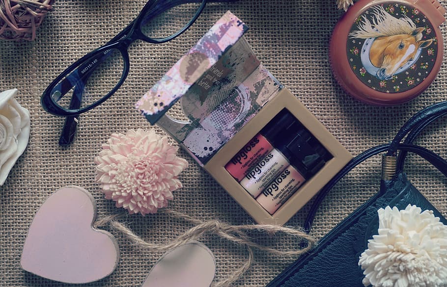 Flat Lay Photography of Lipstick , Eyeglasses and Heart Hanging Decor