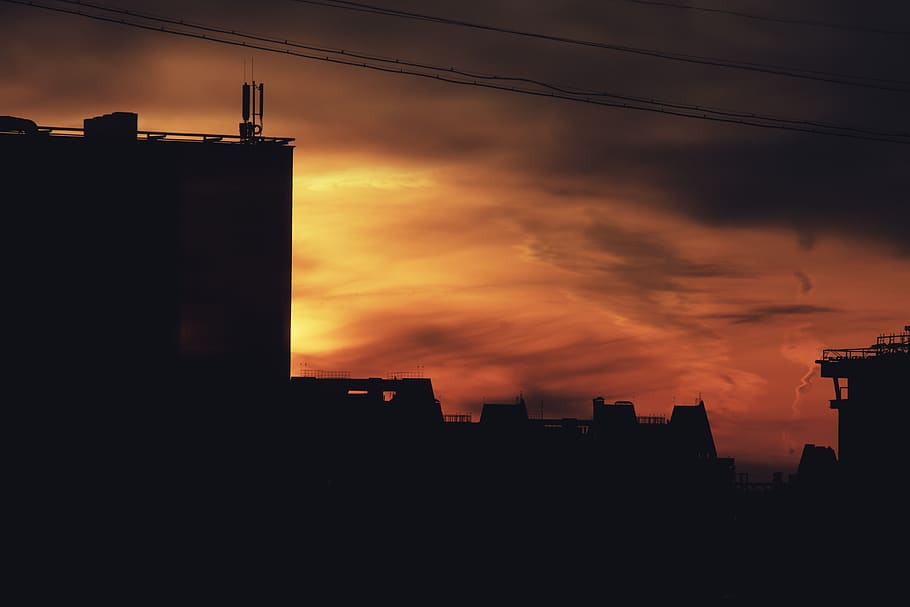 silhouette of houses and buildings under red and orange sky, nature