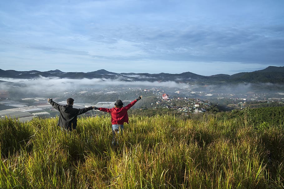 Man and Woman Lifting Hands on Grass Field, adventure, beautiful HD wallpaper