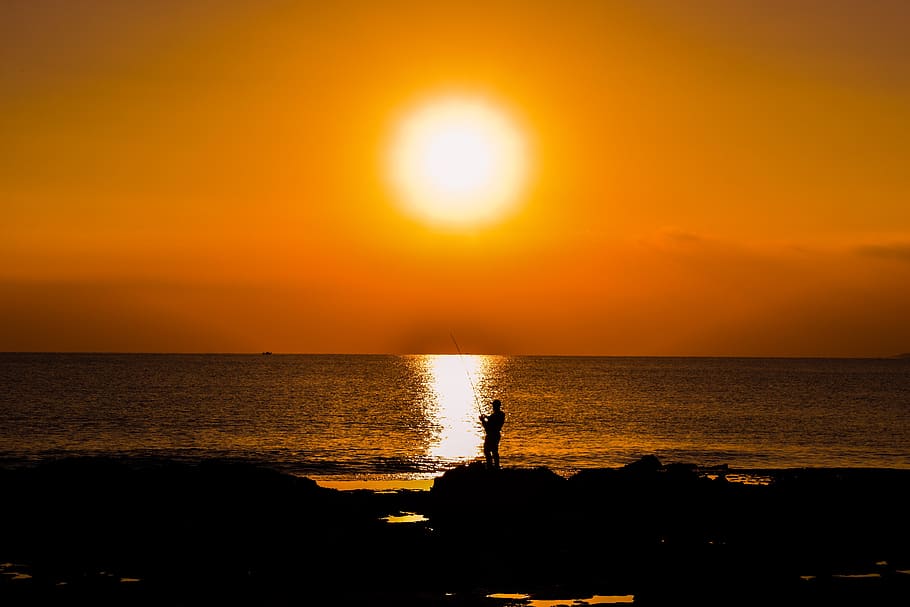 sunset, dusk, sea, fisherman, silhouetted, rocky coast, sky HD wallpaper