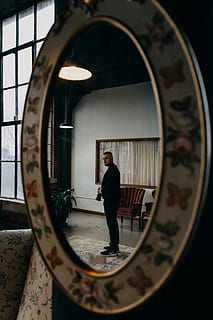 Man Standing Near Couch Holding Camera, black jacket, black pants HD wallpaper