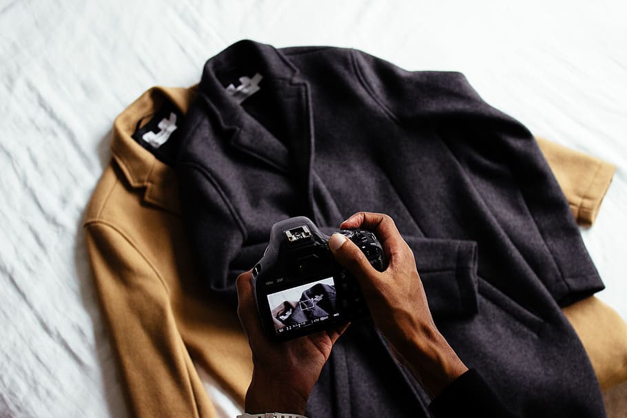 clothing, brown, black, jacket, coat, camera, hand, people HD wallpaper