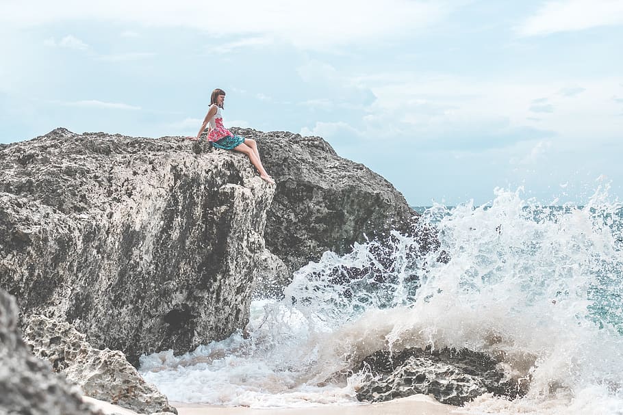 Woman Sitting of Rock Near Body of Water, clouds, coast, daylight HD wallpaper