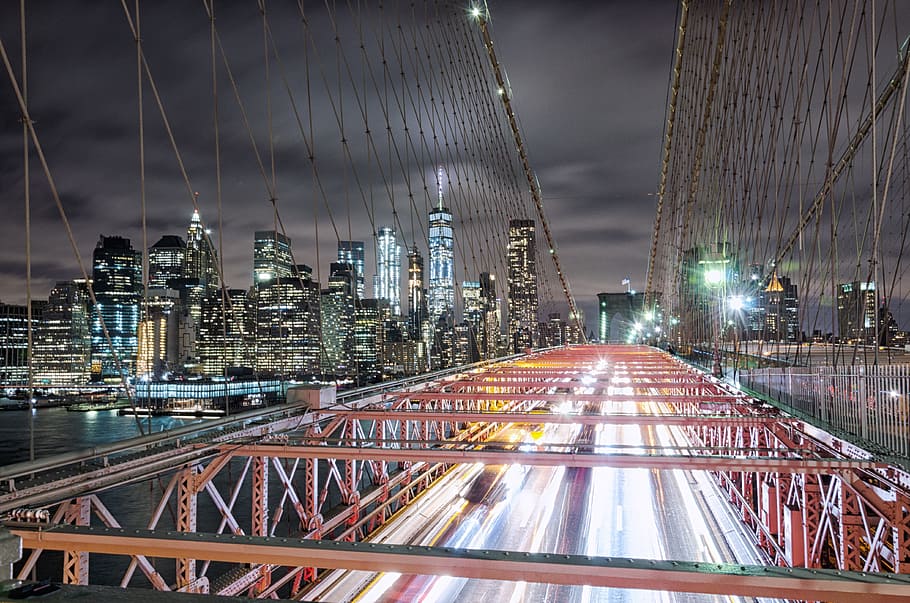 red metal bridge overlooking high rise building, car, light, motion HD wallpaper