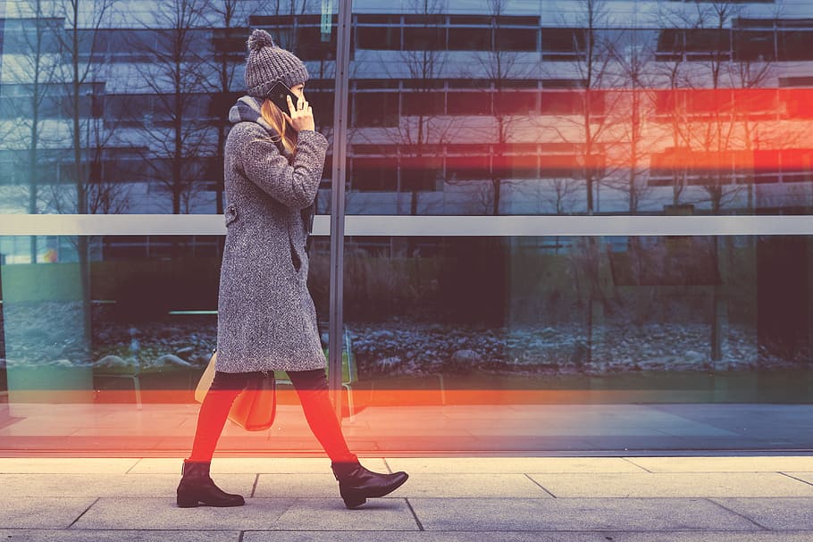 Trendy business woman goes and calling with her smartphone at the office center HD wallpaper