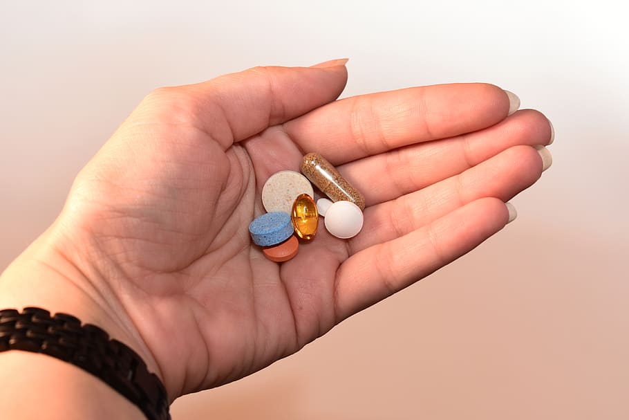 Person Holding Medication Pill and Capsules, blue, bracelet, close-up