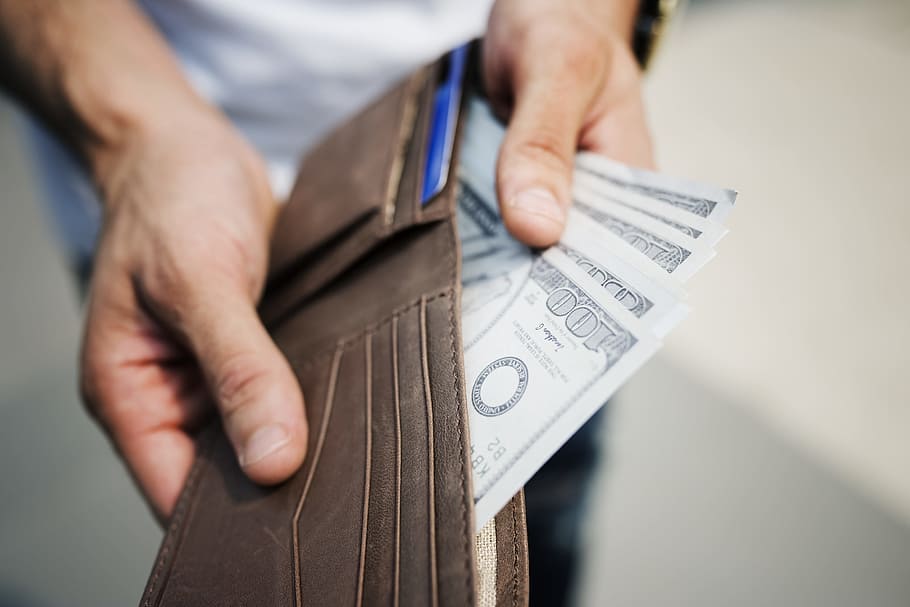 Man Holding Brown Leather Bi-fold Wallet With Money in It, alone