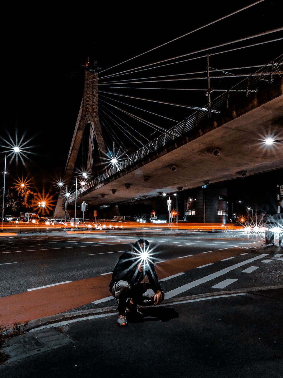 man squatting on pathway during night, illuminated, street, road HD wallpaper