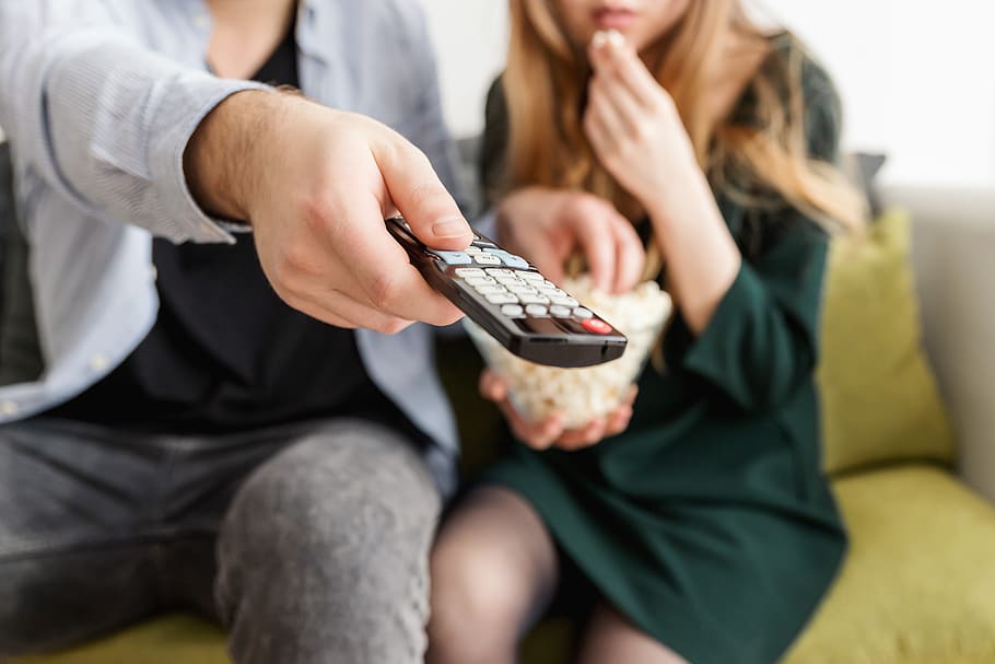 Happy young couple sitting and watching TV at home, adult, women