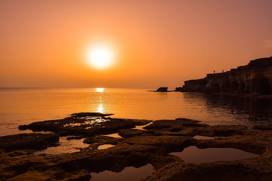 sunset, dusk, sea, water, rock, cliff, shadows, landscape, orange HD wallpaper