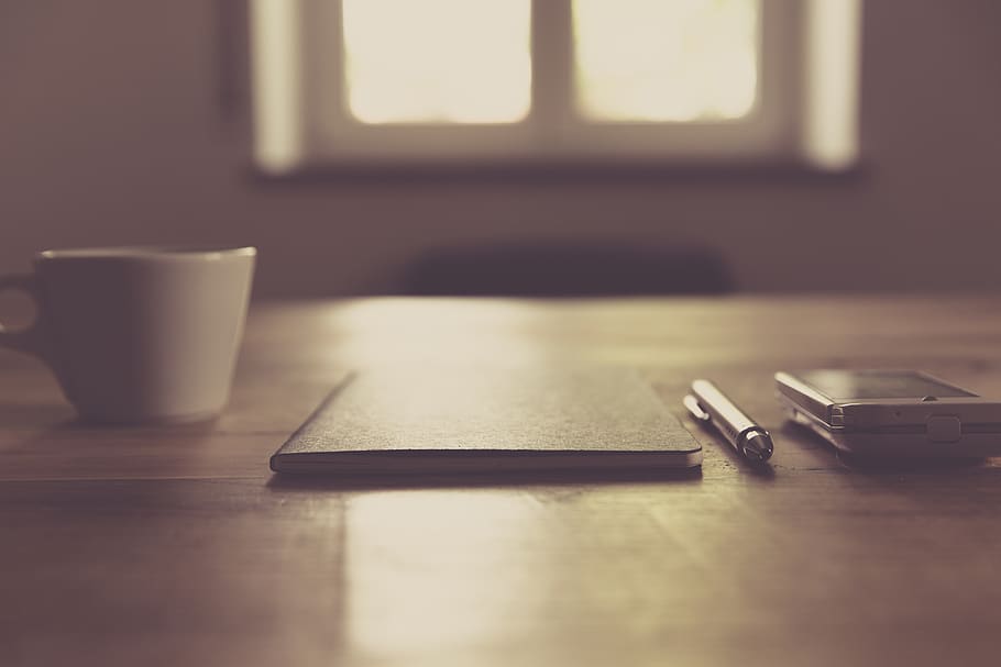 Black Closed Notebook Beside Click Pen and White Cup, desk, smartphone HD wallpaper