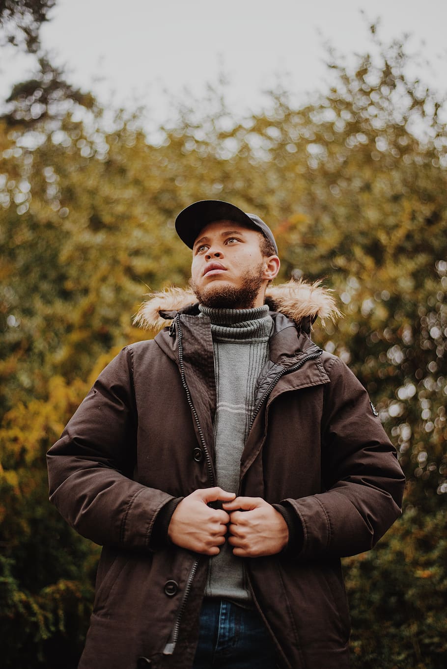 man in brown parka jacket standing, clothing, one person, real people HD wallpaper