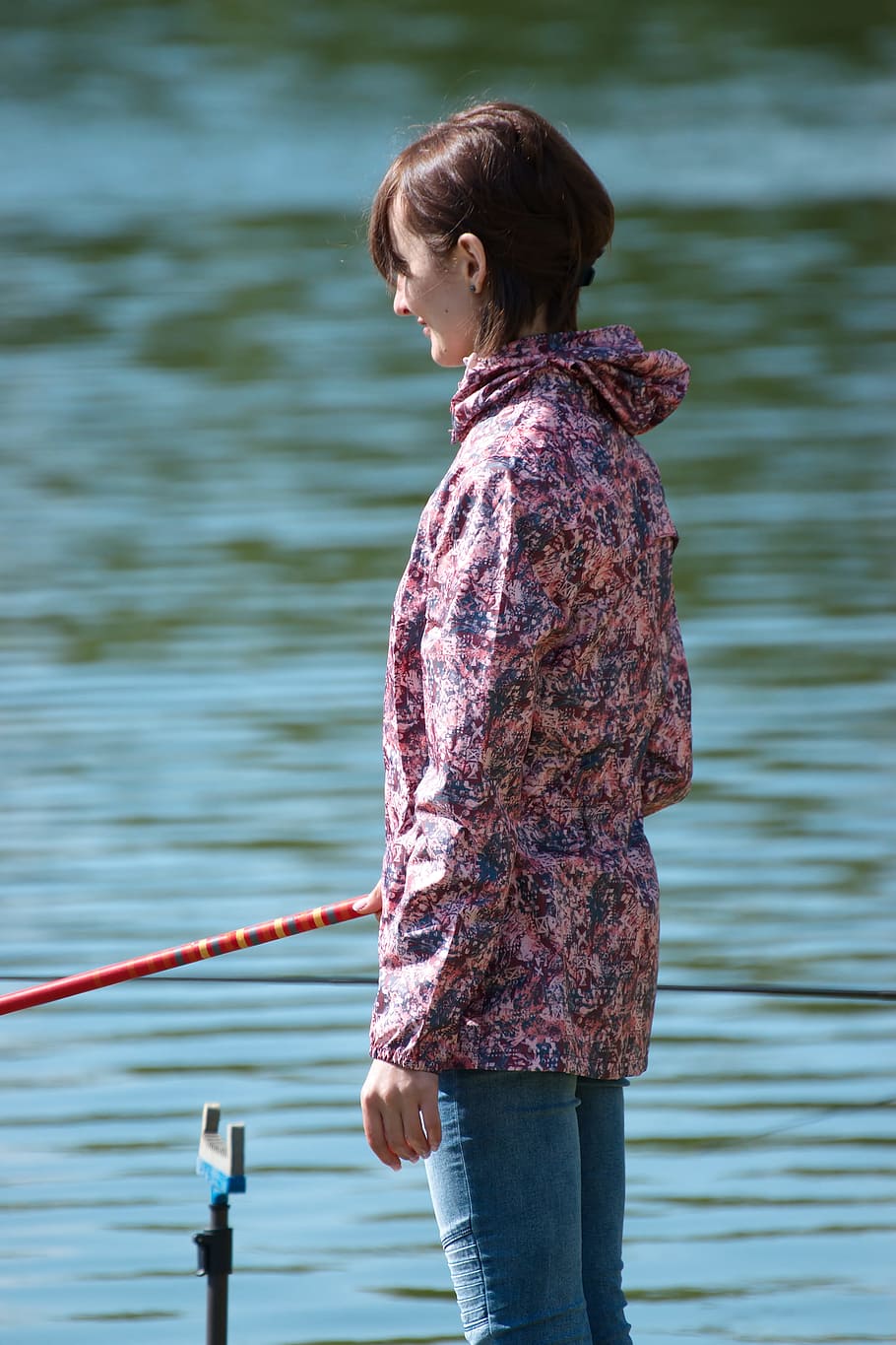 Selective Focus Photography of Woman Holding Red Fishing Rod Standing Beside Calm Body of Water HD wallpaper