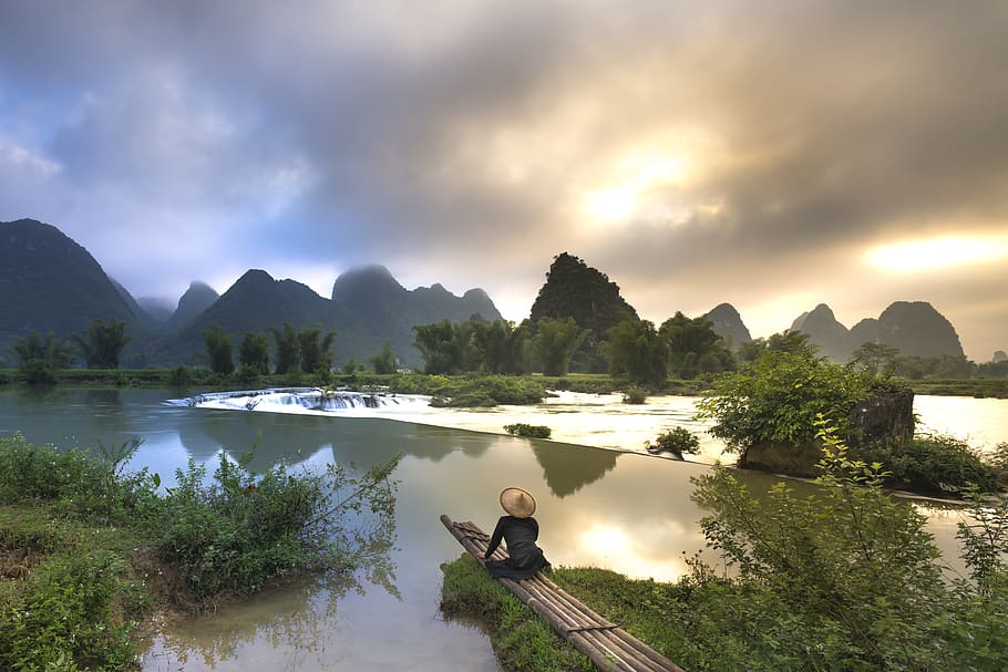 Person Sitting on Bamboo Near Body of Water, bamboo boat, clouds HD wallpaper