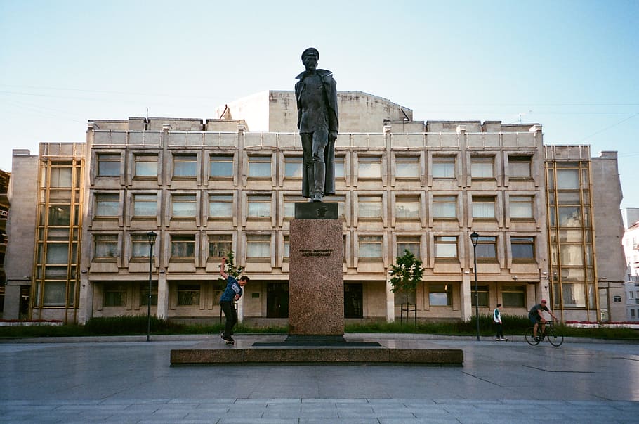 Man Standing Beside Concrete Statue, architecture, bicycle, biker HD wallpaper
