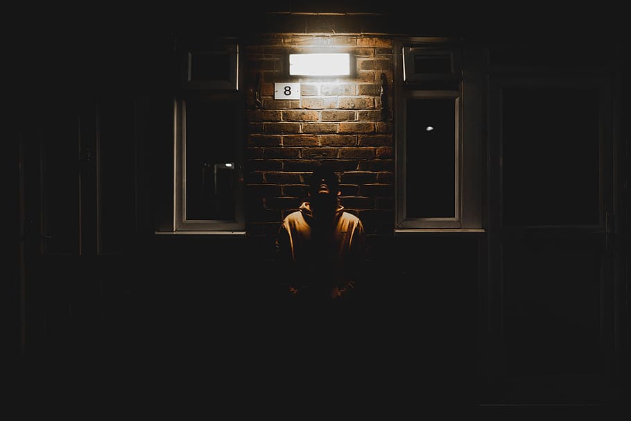 man leaning on wall during nighttime, person, human, clothing