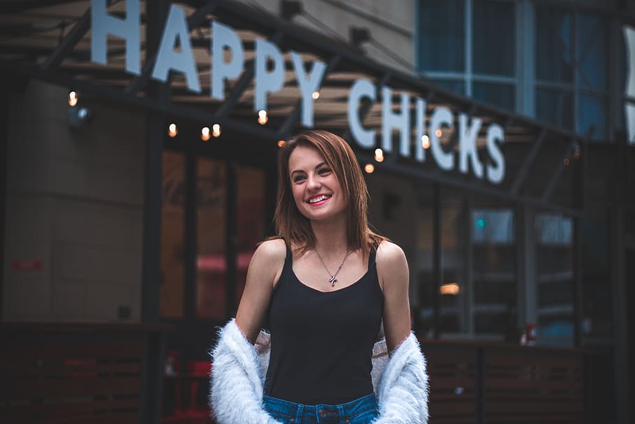 woman wearing black tank top near Happy Chicks signage, apparel