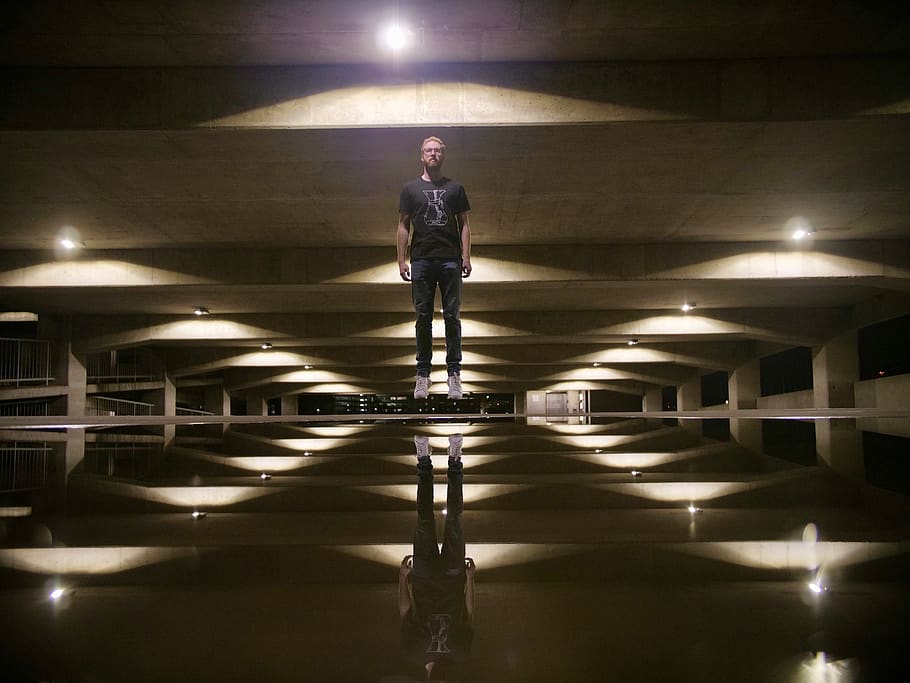 man standing under building, human, person, lighting, corridor