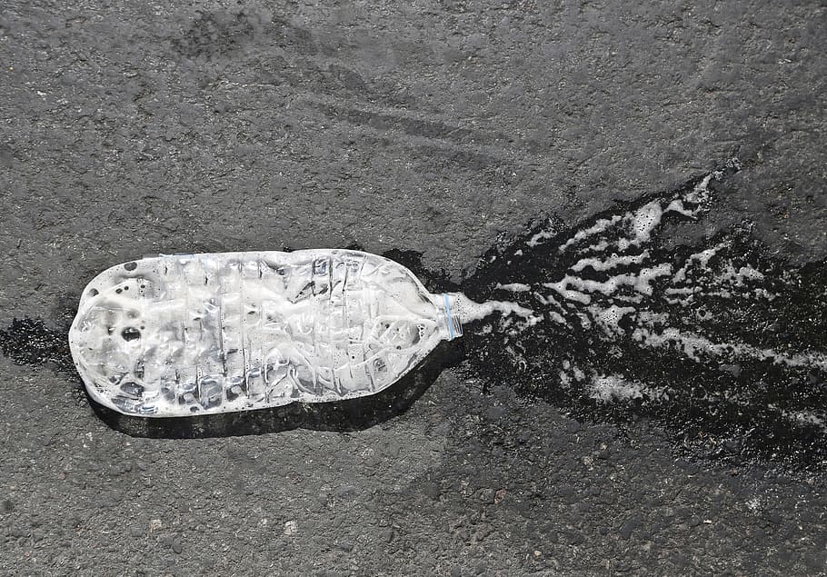 A crushed water bottle on the asphalt road, Beverage, Black And White