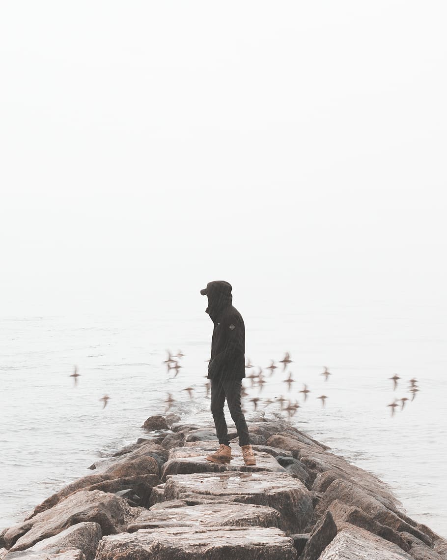 guy, beach, rocks, sand, raining, man, water, ocean, people HD wallpaper
