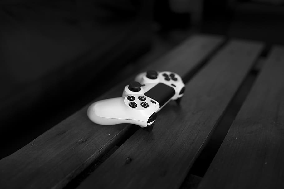 White Sony Dualshock 4 Controller on Black Wood Surface, black-and-white