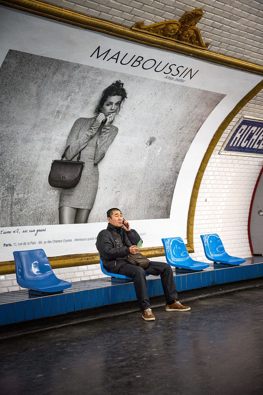 Man Sitting on Blue Chair in Front of Mauboussin Signage, building HD wallpaper