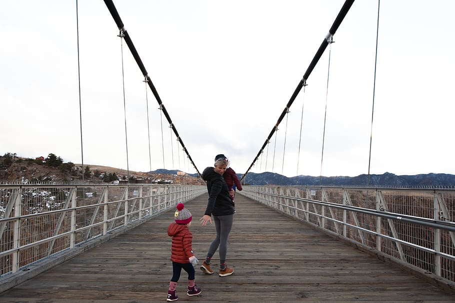 Woman Carrying Child Walking Along Bridge, architecture, children HD wallpaper