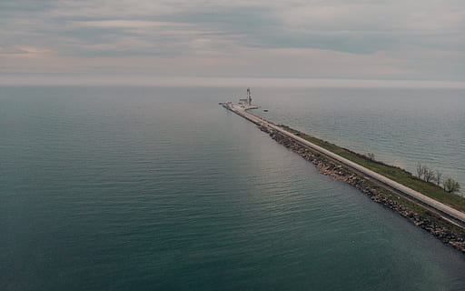 Aerial view of a road leading to a large seaport with horizon in the background HD wallpaper