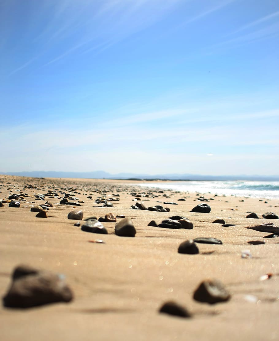 Brown Sand Seashore With Brown Pebbles Under White and Blue Cloudy Skies HD wallpaper