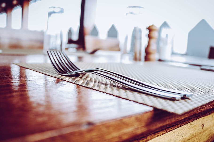 Two Stainless Steel Forks on Top of Place Mat, blurred background HD wallpaper
